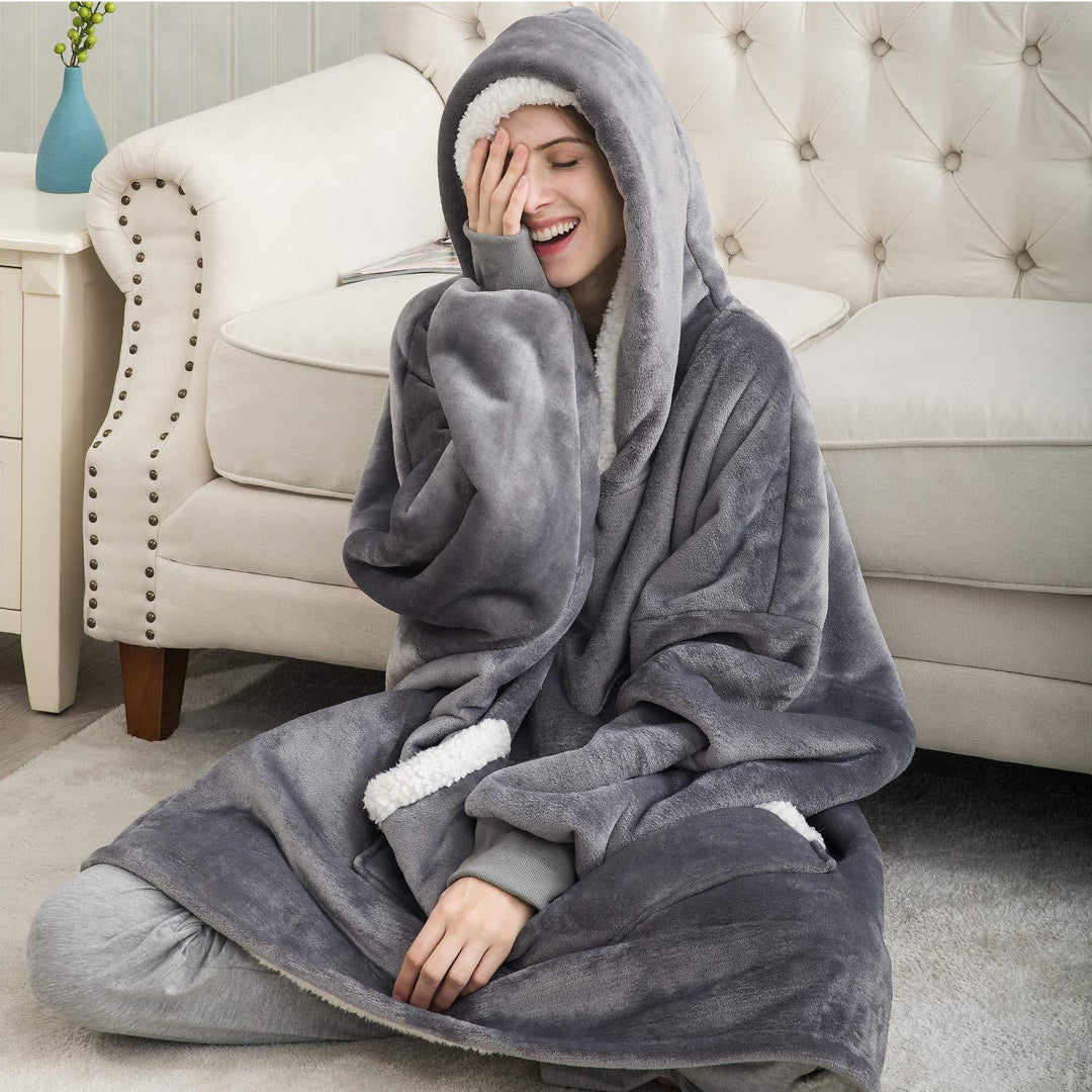 Woman sitting on a white sofa wearing a cozy grey thermal fleece hoodie