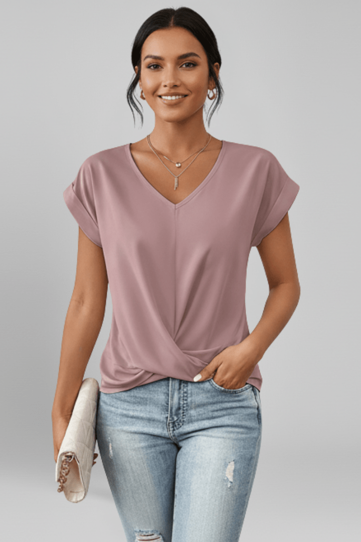 Model wearing pink V-neck short sleeve blouse with a handbag