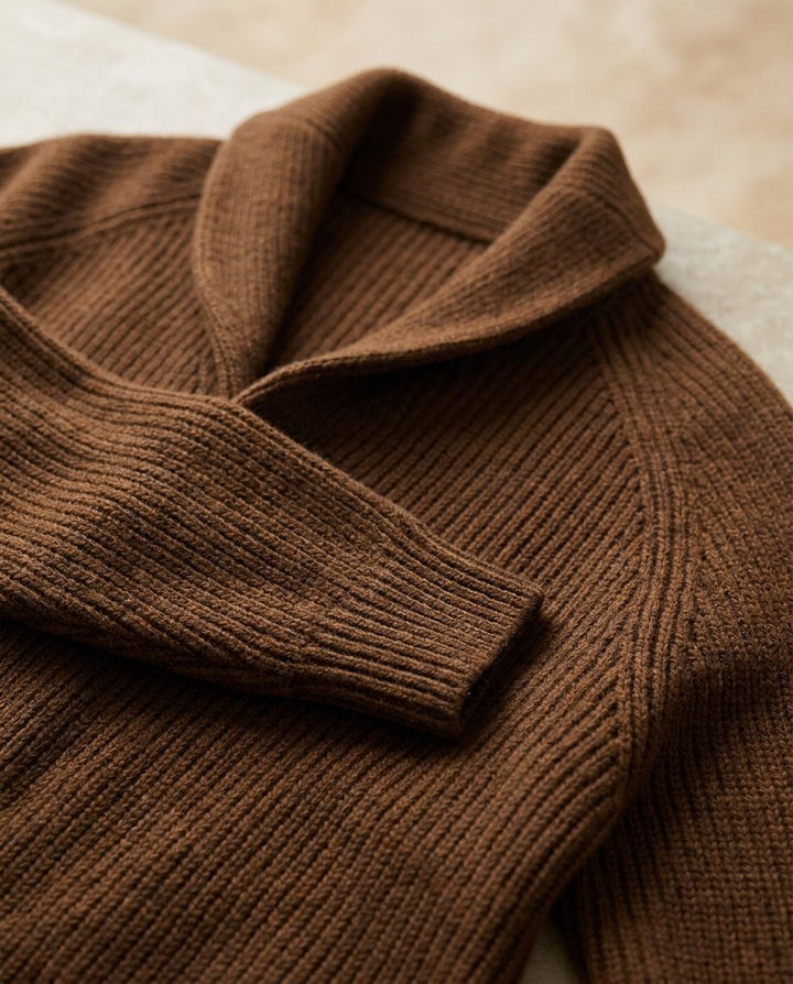 Close-up of the textured knit fabric and sleeve cuff on the brown cardigan