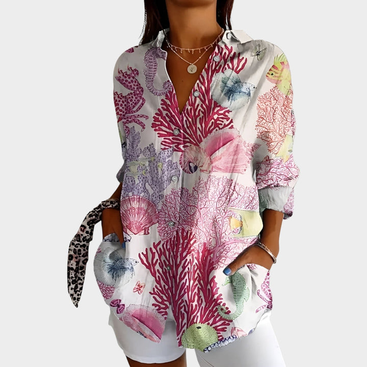 Woman wearing a white and pink coral motif printed button-up blouse
