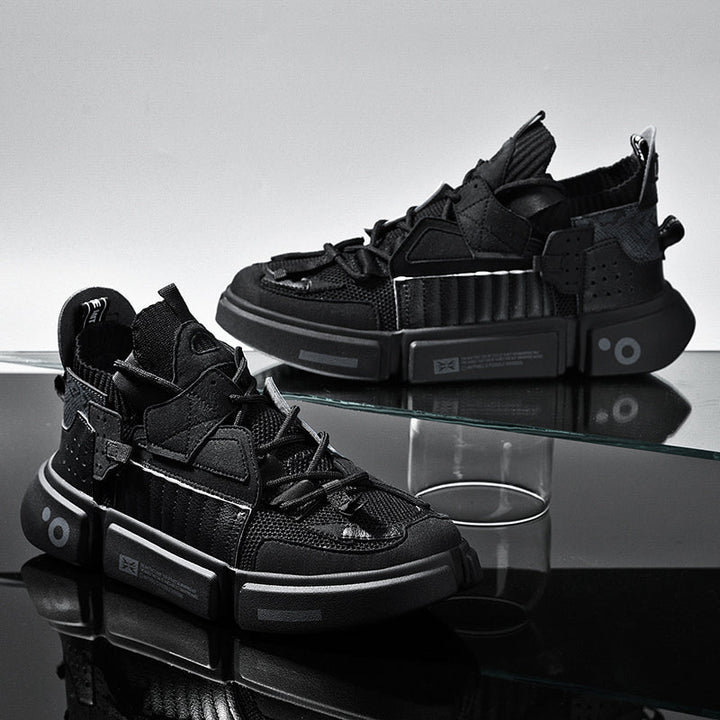 All-black modern men's trainers displayed on glass surface