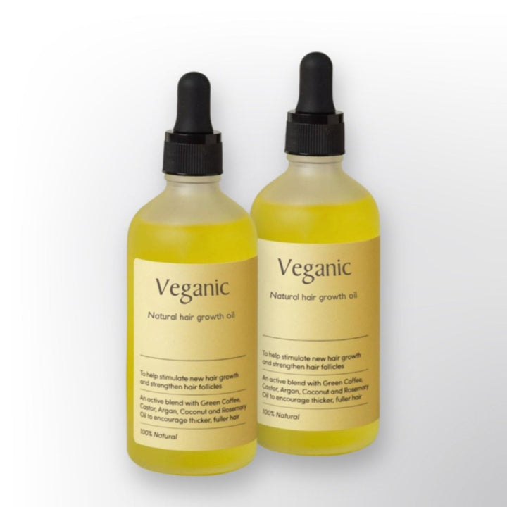 Two bottles of Veganic natural hair growth oil featuring glass droppers