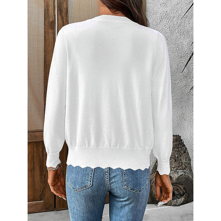 Close up of scalloped hem and button closure on v-neck knit cardigan