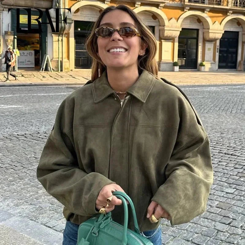 Woman wearing green oversized cropped bomber jacket with sunglasses outdoors