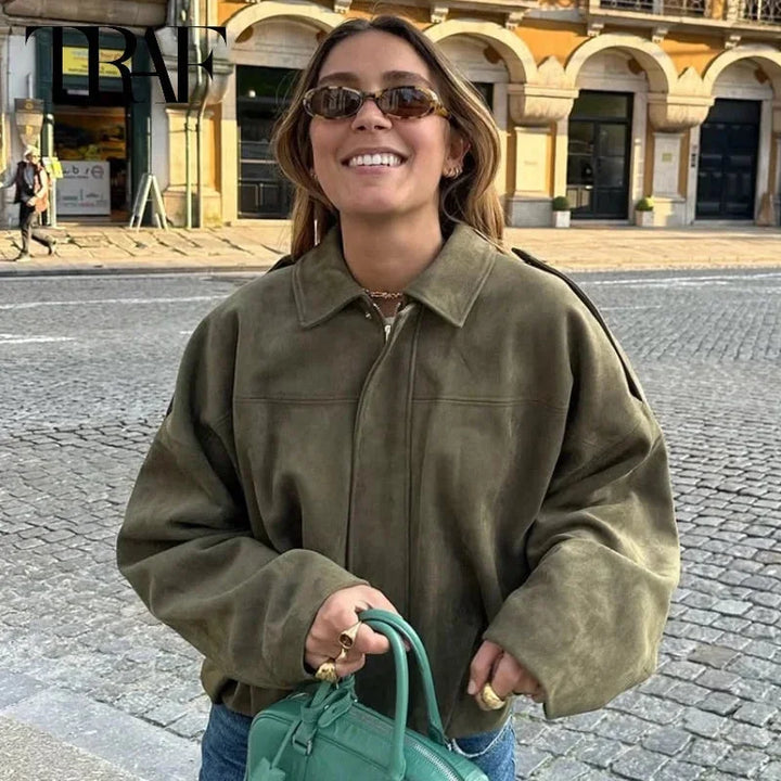 Woman wearing green oversized cropped bomber jacket with sunglasses outdoors