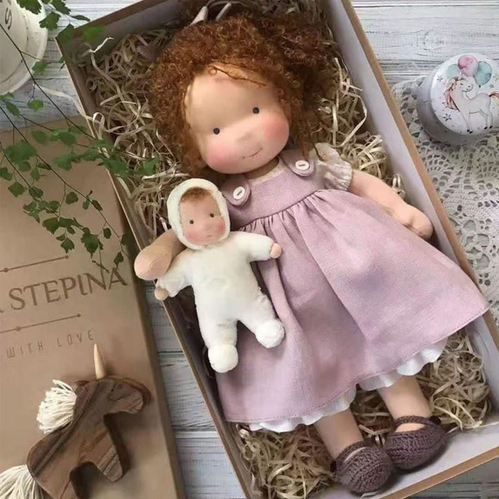 Handmade Waldorf doll with a purple dress displayed in a gift box alongside a smaller toy figure