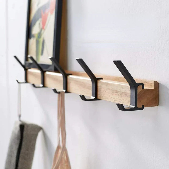 Close-up of the black aluminum double hooks on a natural wood wall coat rail