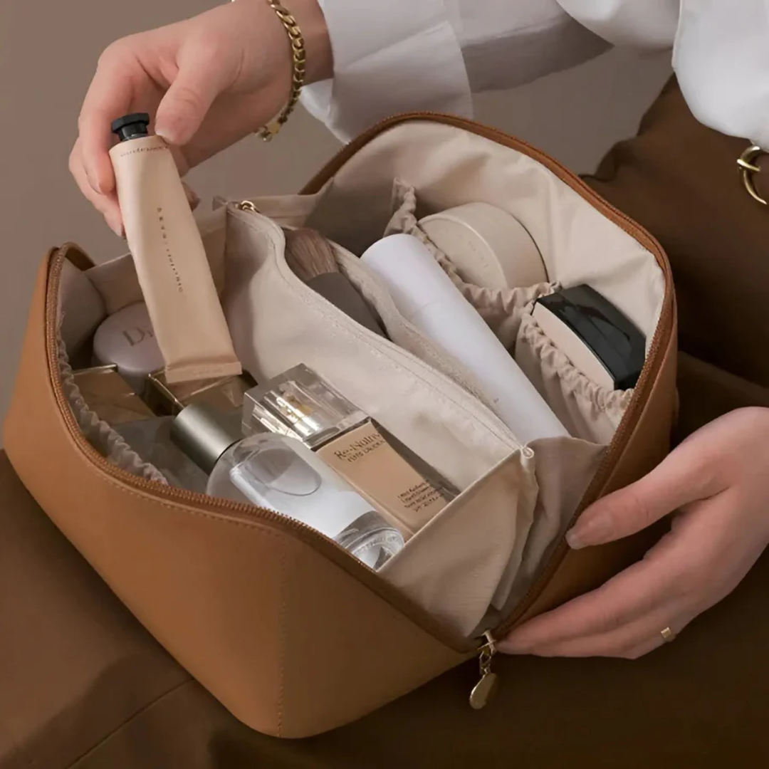 Brown makeup organizer bag being packed with creams and bottles