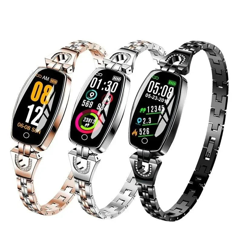 Three fitness trackers in gold, silver, and black displaying colorful screens and metallic link bands