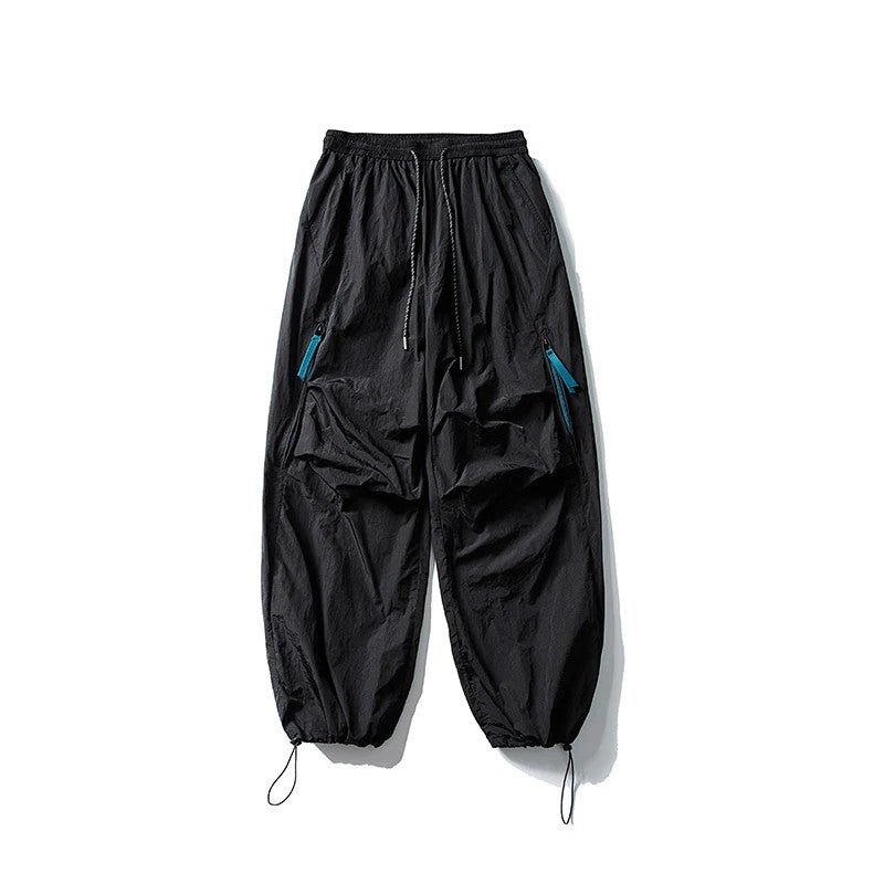Black waterproof hiking pants laid flat showing elastic waist and zipper details