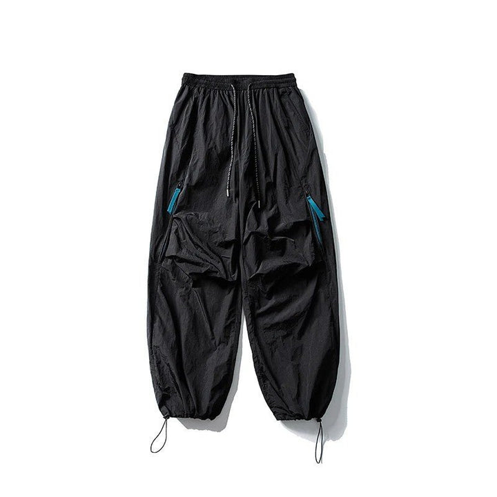 Black waterproof hiking pants laid flat showing elastic waist and zipper details