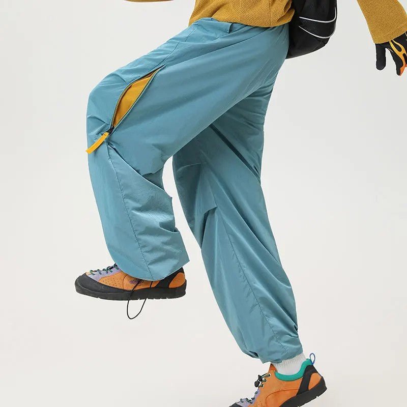 Person wearing blue outdoor hiking pants demonstrating flexibility and side zipper