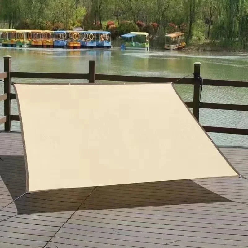 Sun shade sail mounted over a backyard pool and deck area