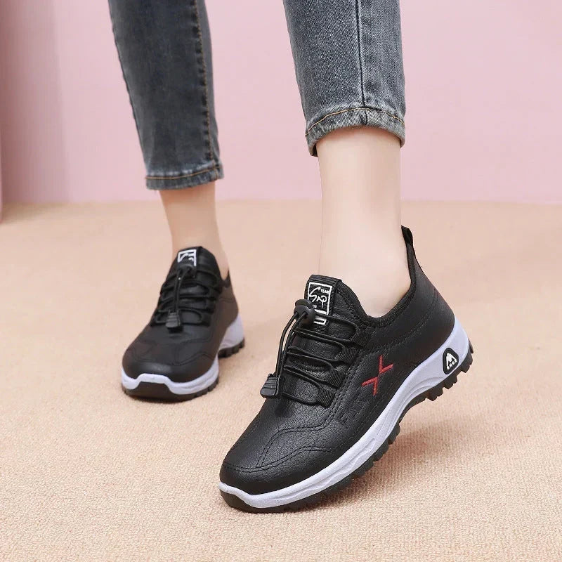 Black waterproof women's trainers displayed on a neutral background