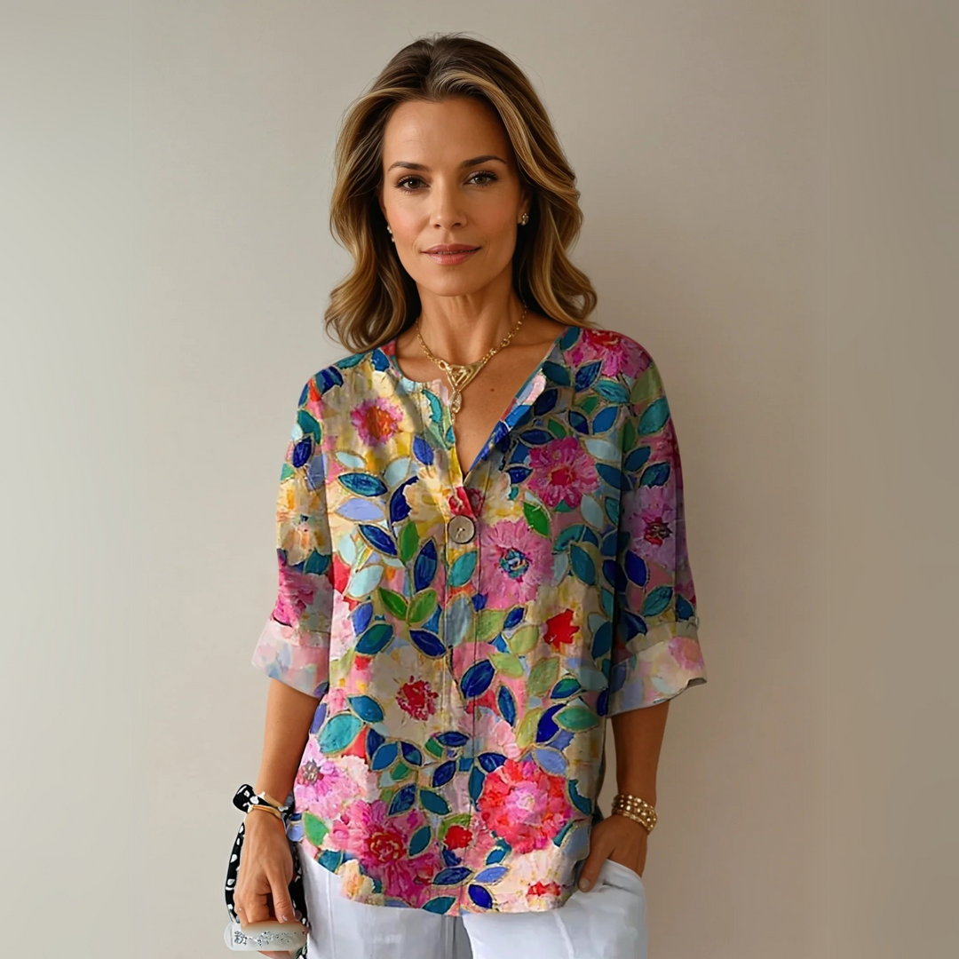 Woman wearing a colorful floral V-neck summer blouse with short sleeves