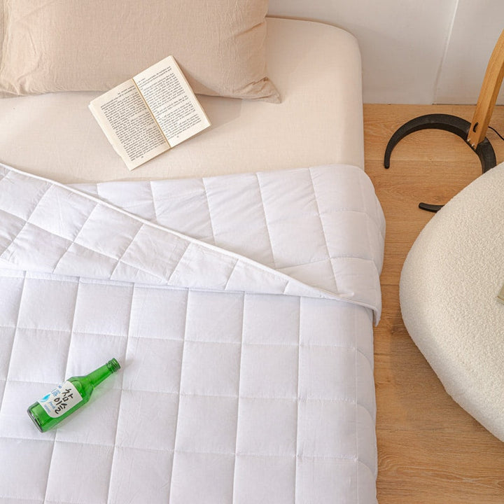 Gravity blanket draped over a cozy bed for anxiety relief and deep relaxation