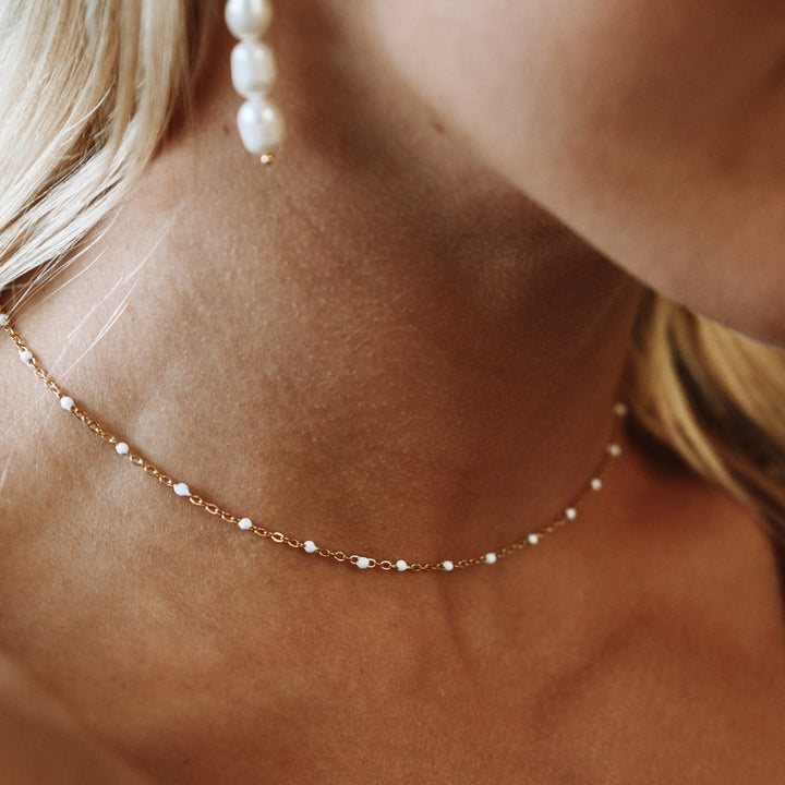 Close-up of waterproof white enamel beaded choker necklace, hypoallergenic
