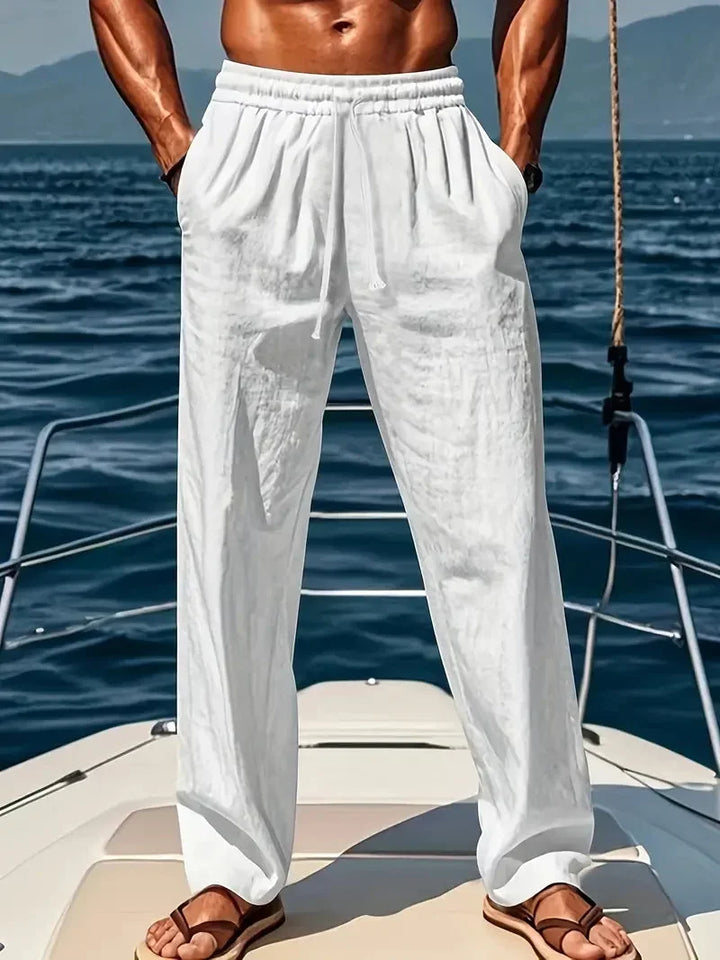 Man wearing white relaxed wide-leg trousers on a boat deck