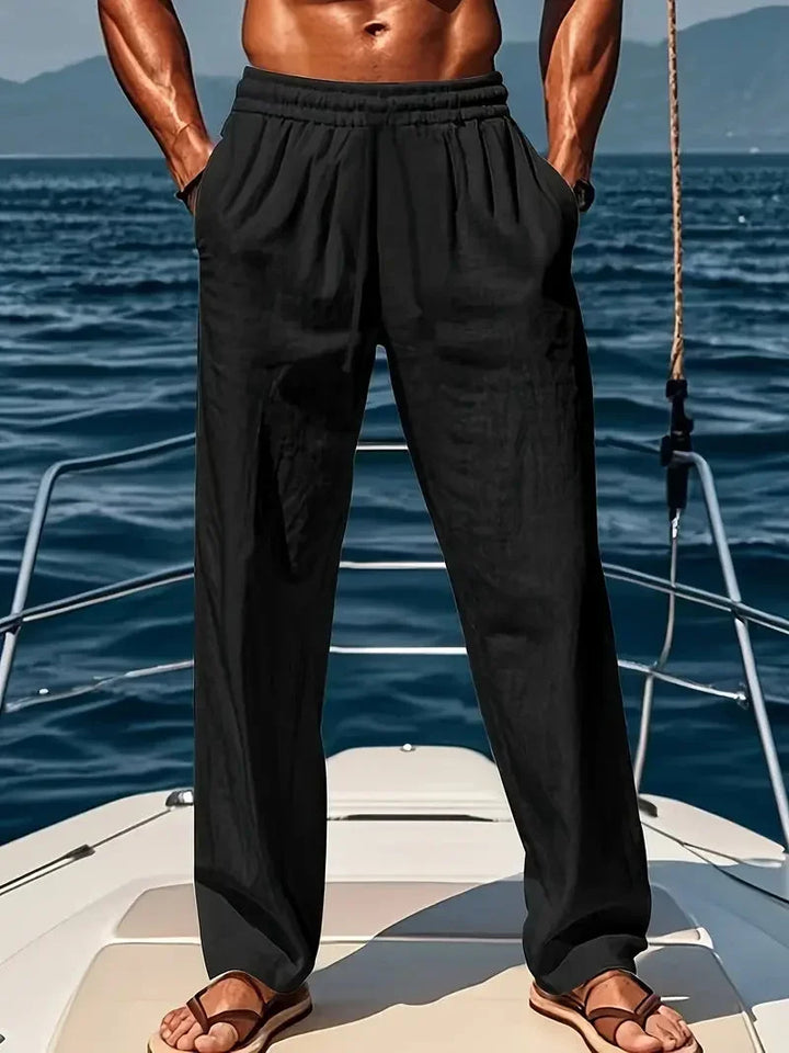 Man wearing black relaxed wide-leg trousers on a boat deck