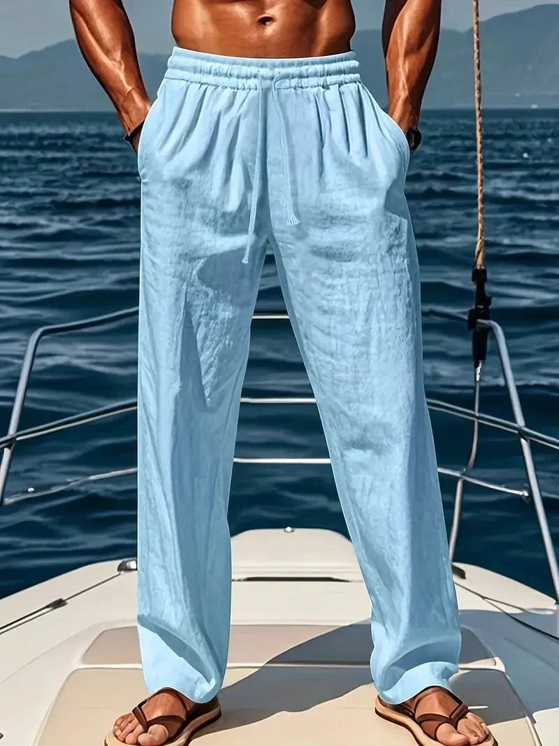 Man wearing light blue relaxed wide-leg trousers on a boat deck