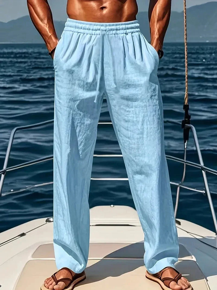 Man wearing light blue relaxed wide-leg trousers on a boat deck