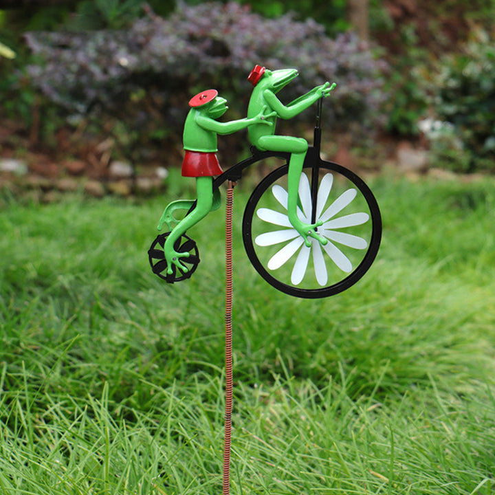 Frog variant of the Willy Windmill kinetic garden stake installed in lush green grass