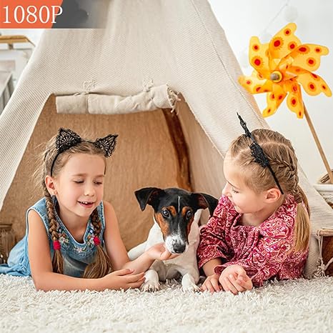 Children playing in a tent next to a dog, monitored by a home camera
