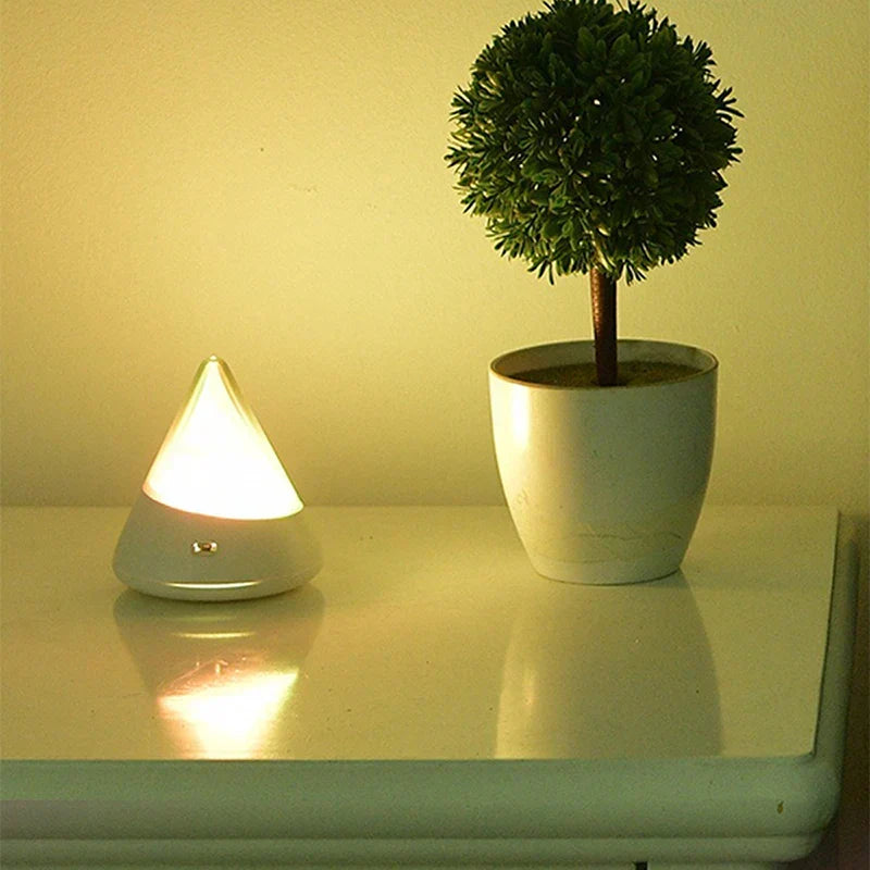Iceberg night light casting a warm glow on a bedside table next to a plant
