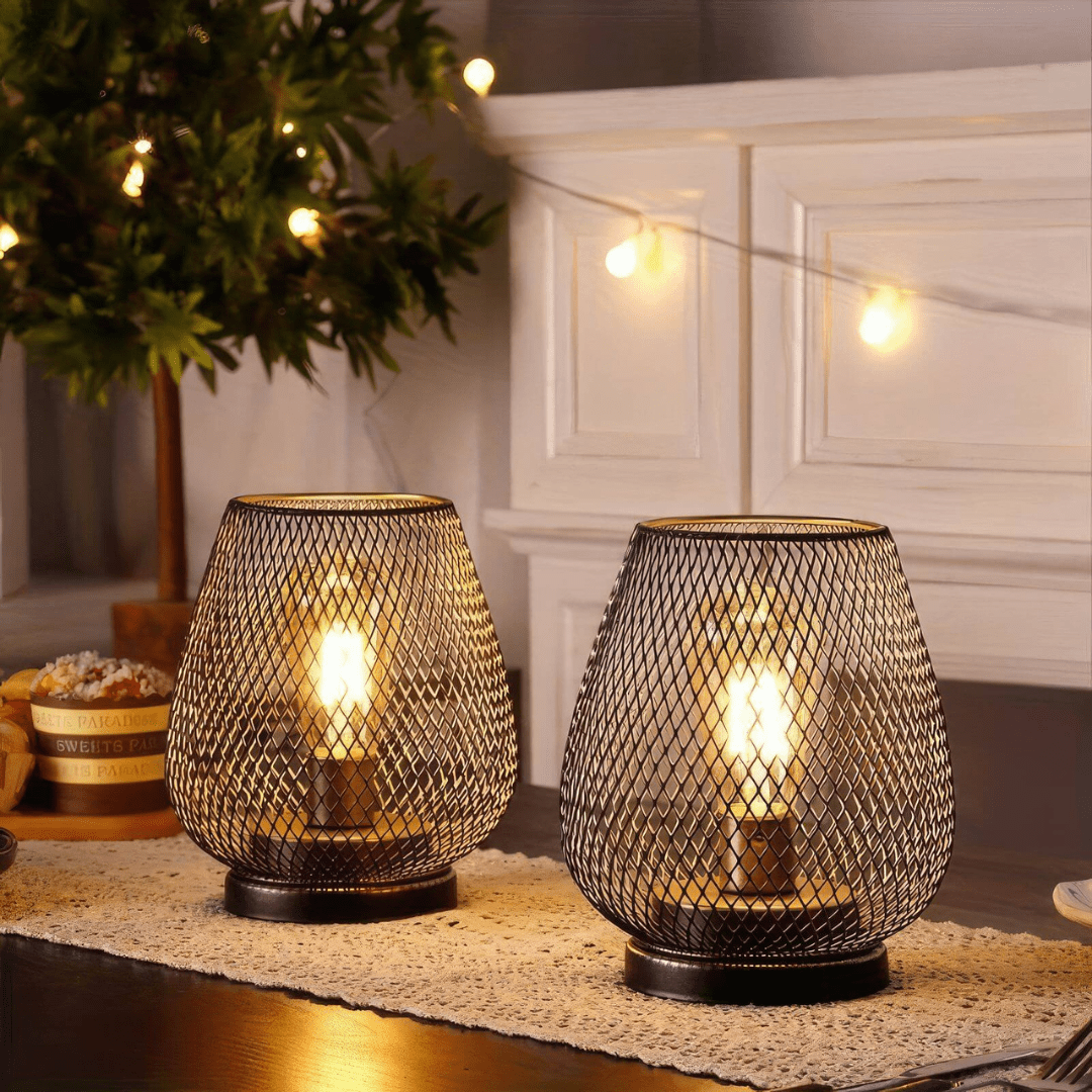 Two modern wireless metal LED lanterns glowing on a dining table decorated with a lace runner.