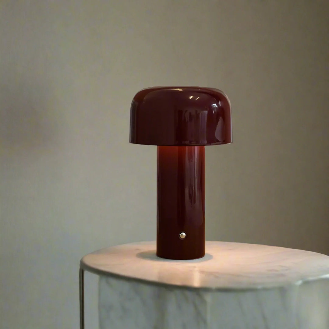 Bordeaux red wireless metal table lamp illuminating a marble accent table