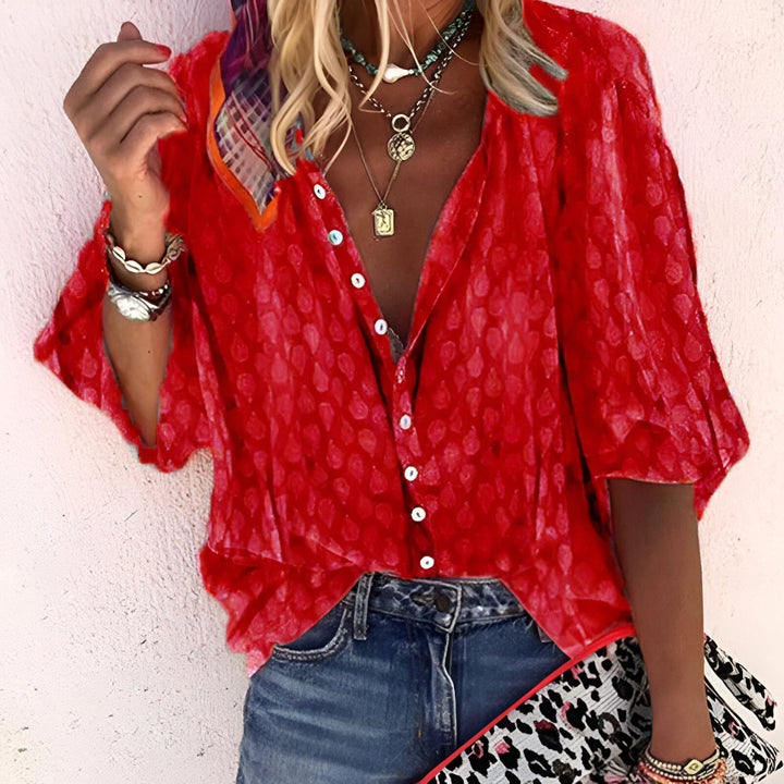 Woman wearing a vibrant red button-up blouse paired with denim jeans