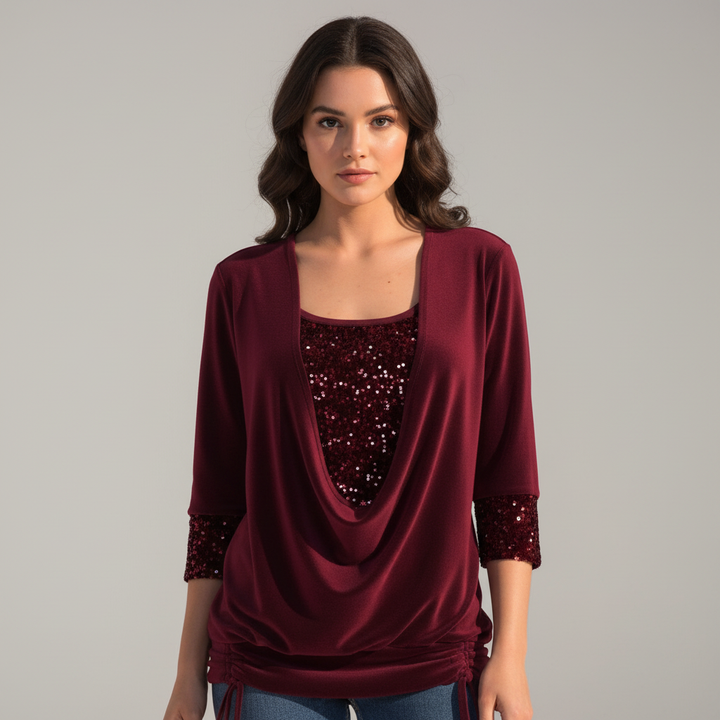 Model wearing a dark red sequin long-sleeve blouse with a draped neckline.