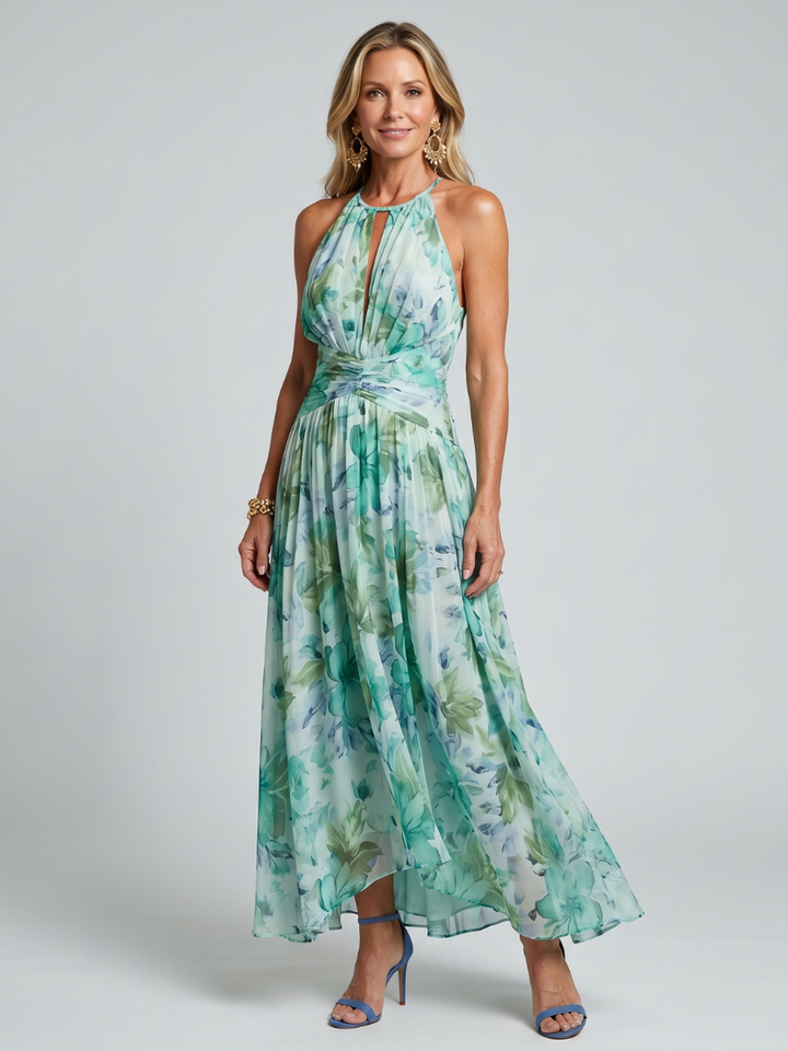 Front full-length view of a woman wearing a green floral halter maxi dress