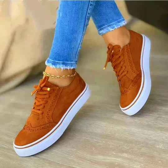 Women wearing brown lace-up sneakers with perforated details