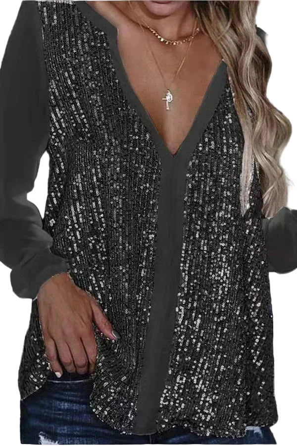 Woman wearing black long sleeve V-neck sequin blouse with layered gold necklaces