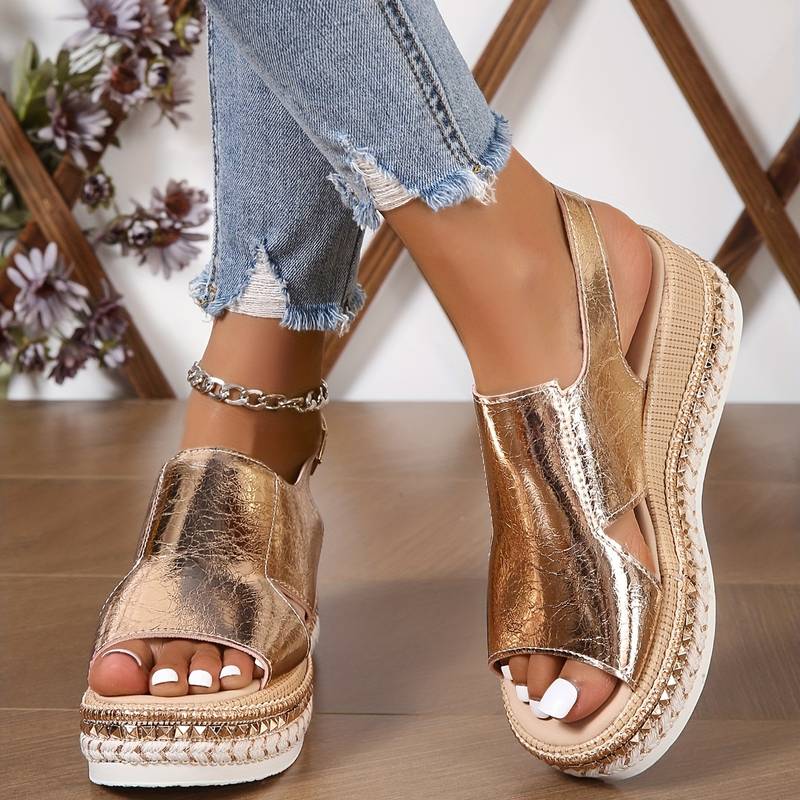 Close-up of gold wedge platform sandals paired with distressed jeans and jewelry