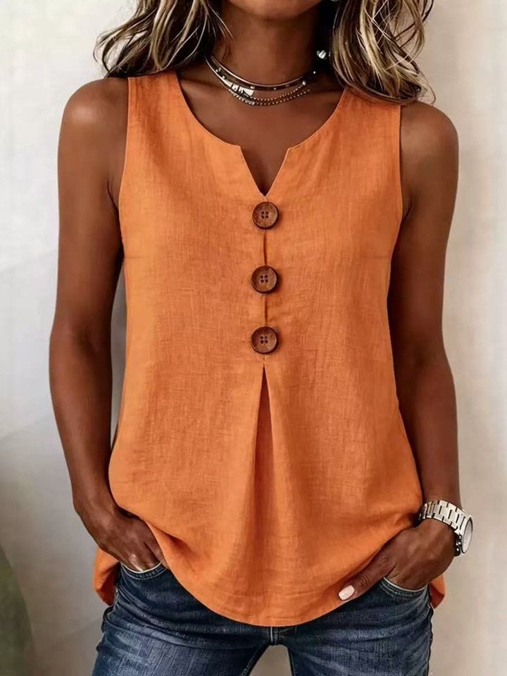 Woman wearing an orange-red sleeveless V-neck blouse with decorative buttons