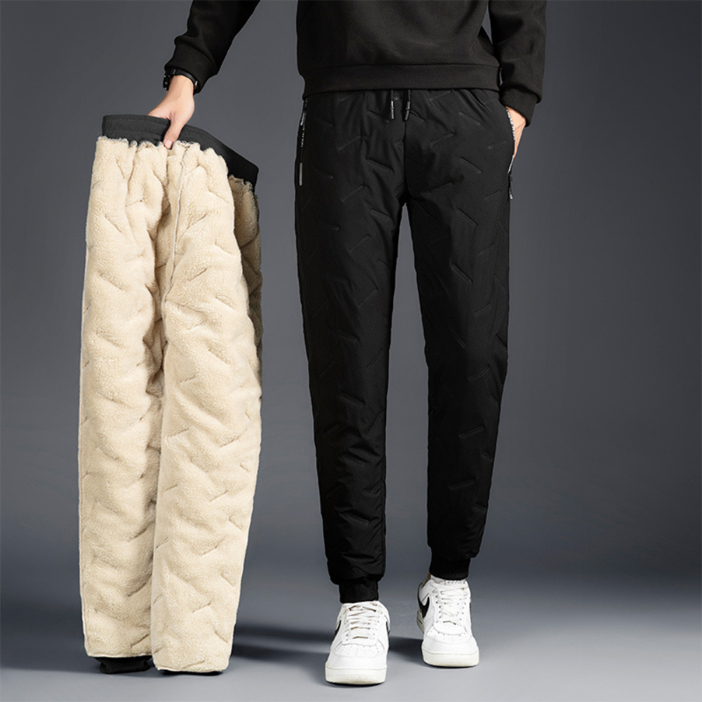 Woman holding black thermal waterproof trousers with fleece lining