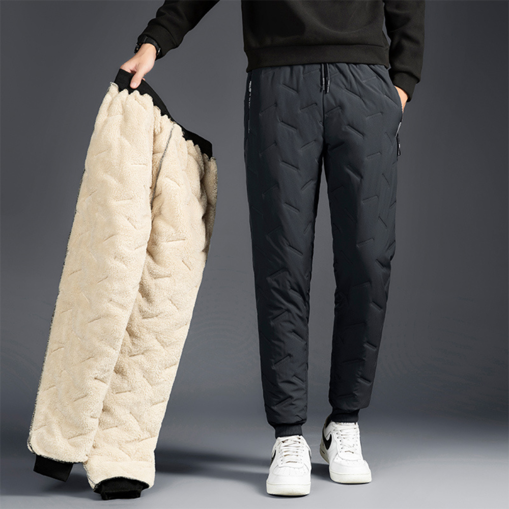 Woman holding grey thermal waterproof trousers showing fleece interior