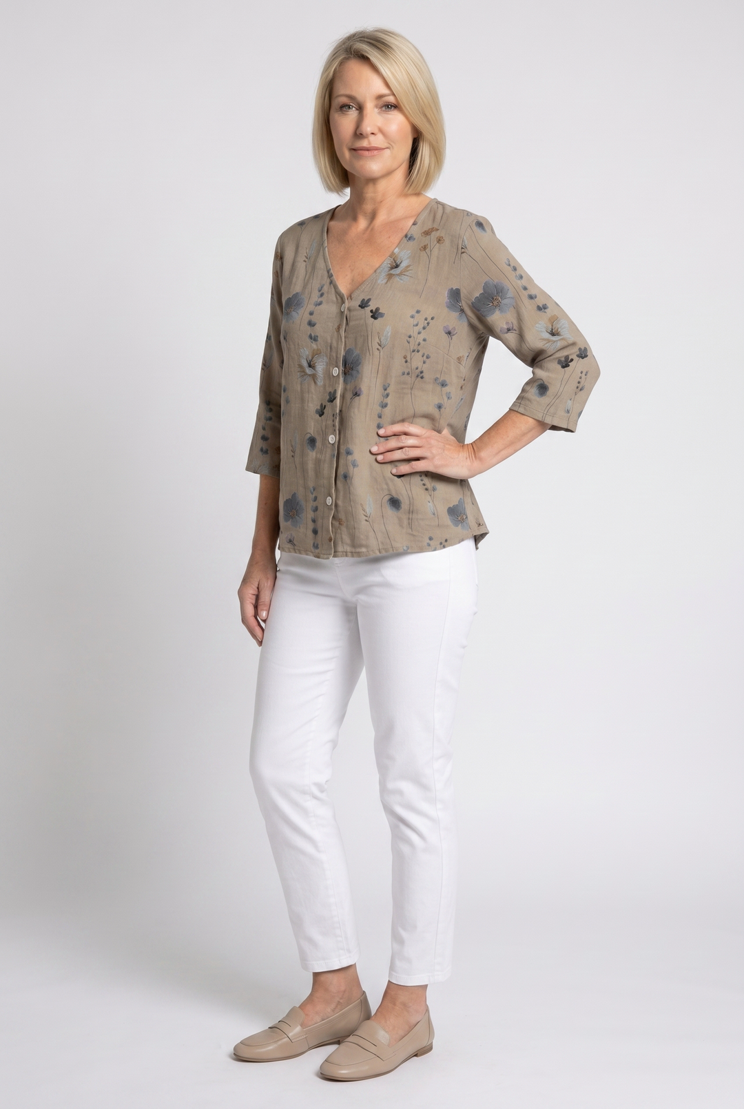 Studio portrait of a woman modeling the floral print V-neck blouse with three-quarter sleeves