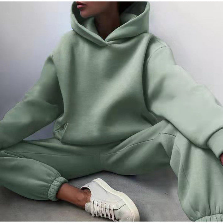 Woman wearing mint green oversized hoodie and jogger pants set sitting on the floor