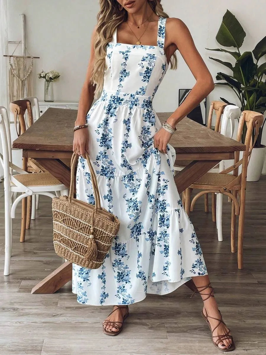 Woman wearing a blue floral maxi sundress with wide straps posing indoors