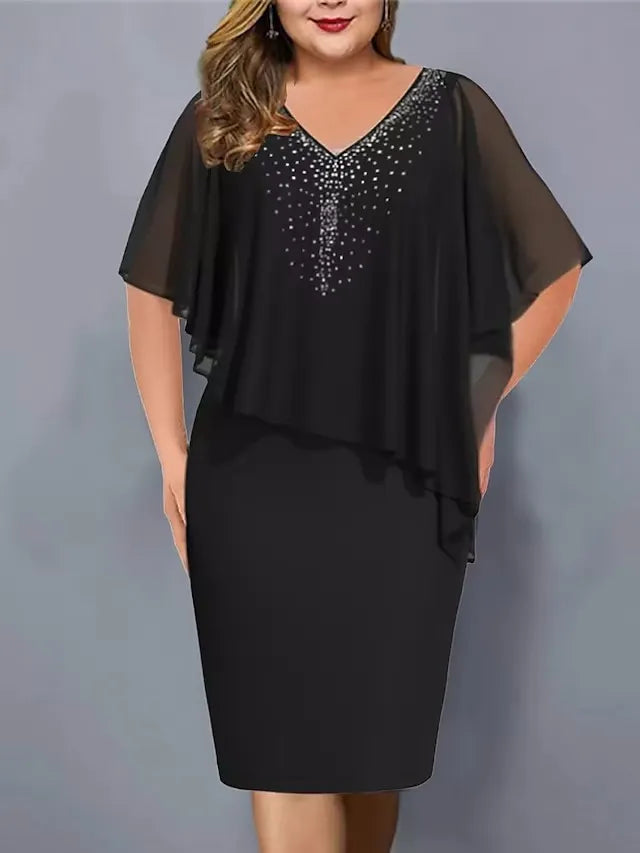 Plus size woman wearing black midi dress with chiffon cape and rhinestone V-neck