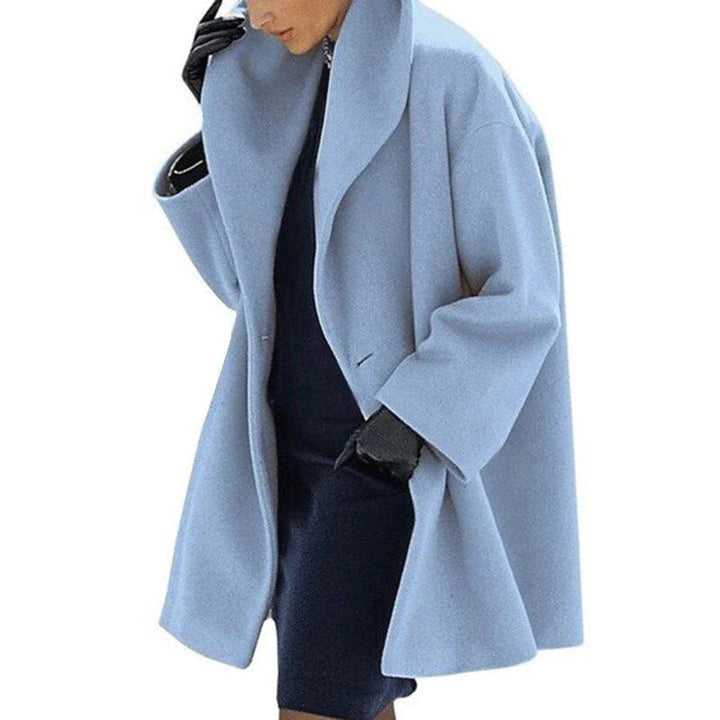 Woman wearing a light blue chic winter jacket with a button closure