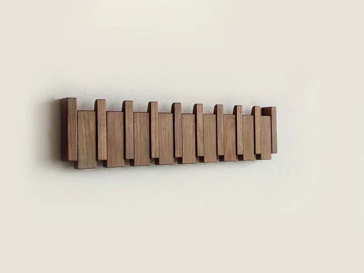Angle view of wooden piano coat rack displaying sturdy construction and hooks