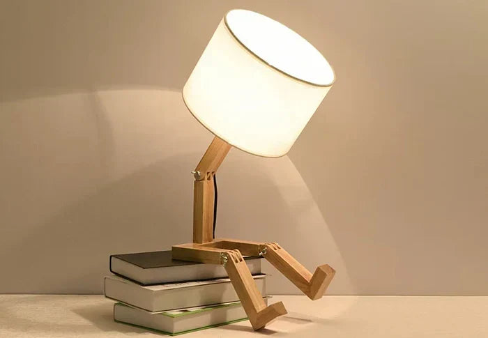 Poseable wooden desk lamp resting on a stack of books