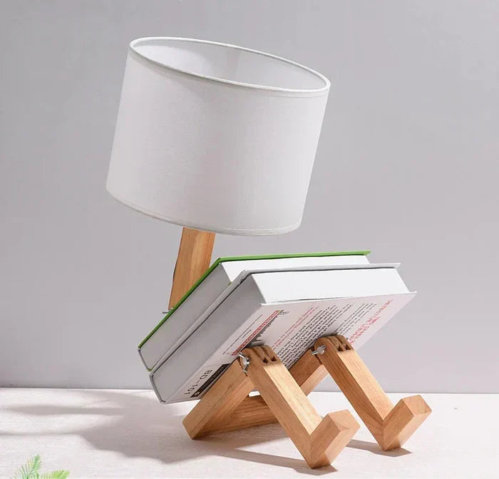 Adjustable wooden robot table lamp casting warm reading light on a desk