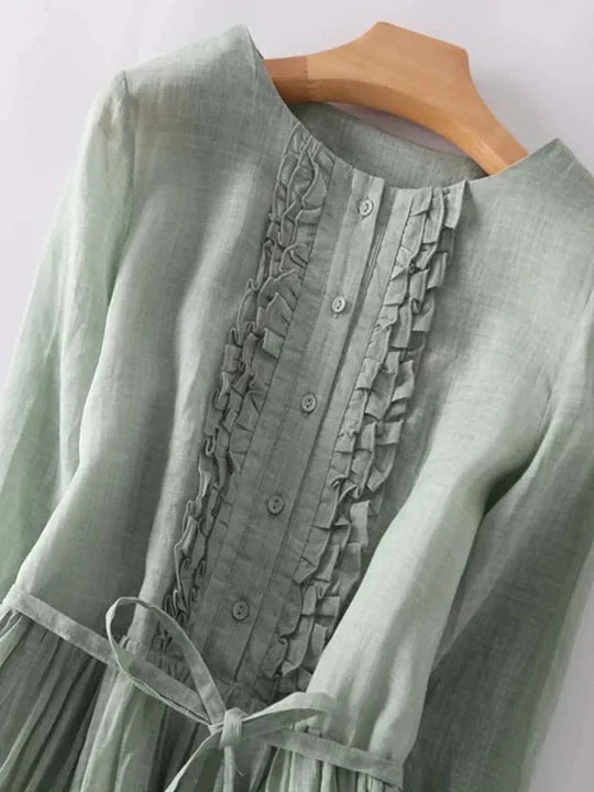 Close-up of green ruffle front maxi dress bodice with buttons and tie waist